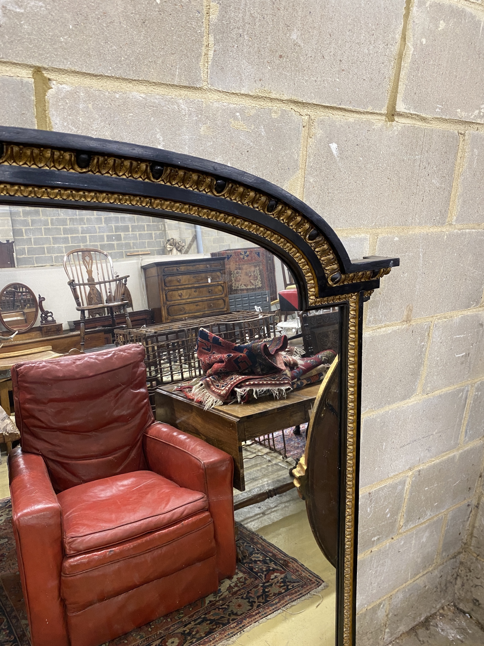 A late Victorian ebonised parcel gilt overmantel mirror, width 151cm, height 154cm